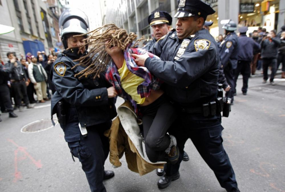 Те, що протестувальниця жінка, не зупинило американську поліцію під час розгону акції «Окупуй Волл-Стрит». Фото з сайту ibtimes.com