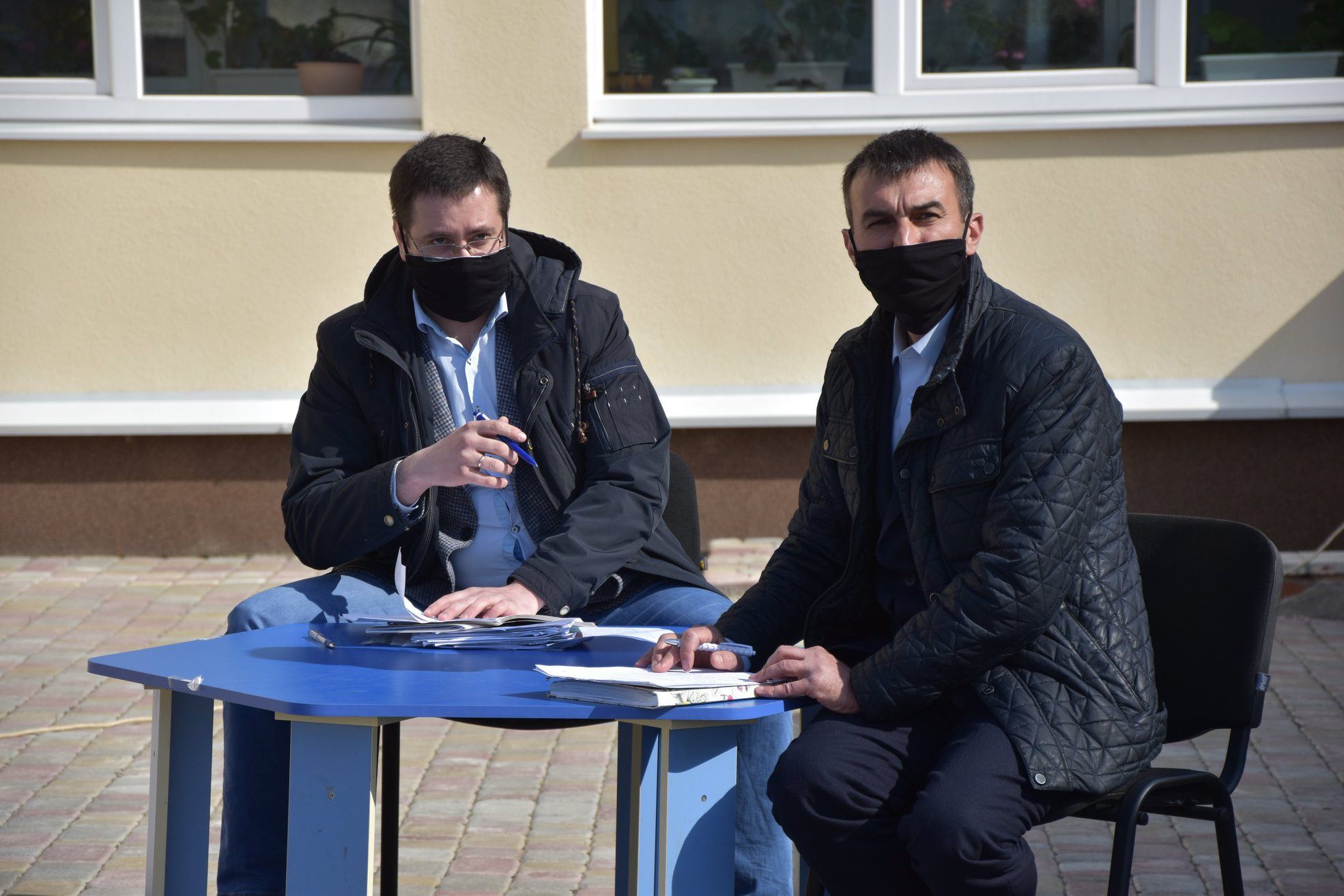 Селищний голова Микола Панчук (праворуч) веде сесію на свіжому повітрі.