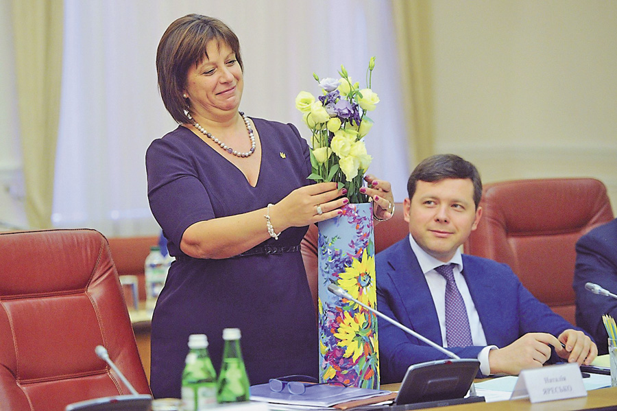 З нагоди перемоги на фінансовому фронті Арсен Аваков подарував Наталії Яресько розписану гільзу від 120-міліметрового снаряда, а Арсеній Яценюк — квіти. Фото УНIAН