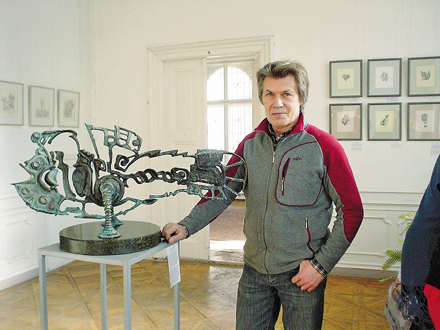 Художник, скульптор, дизайнер Руслан Романишин біля бронзової скульптури «Епоха Риб». Фото надане автором