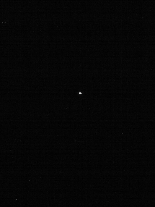 На фотографії можна помітити нашу планету – крихітну яскраву крапку в центрі, а також Місяць – ще більш маленька точка праворуч від Землі.
