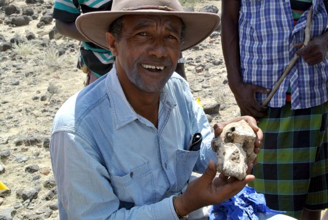 Йоганнес Хайле-Селассіє, який знайшов древній череп в Ефіопії, позує з ним у полі.