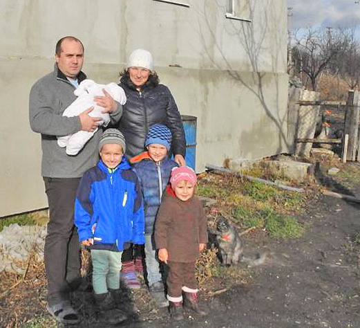 Родина Іванченків поряд з будинком у смт Нижнє Попаснянського району Луганської області. Фото надала Норвезька рада у справах біженців