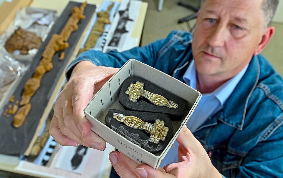 Археолог Арнольд Мюль демонструє золоті мистецькі застібки. Артефактам 1500 років.