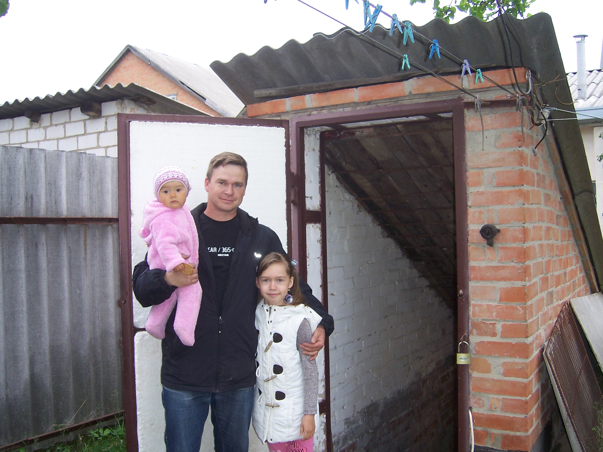 Полтавець Олексій Пацула з доньками біля входу в домашнє бомбосховище. Фото автора